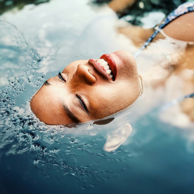 woman submerged in cold plunge with calm expression, homepage cold therapy image promoting recovery