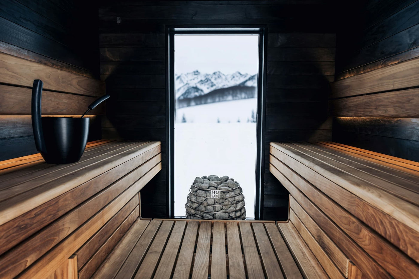 sauna homepage banner interior view of huum heater with mountains in background